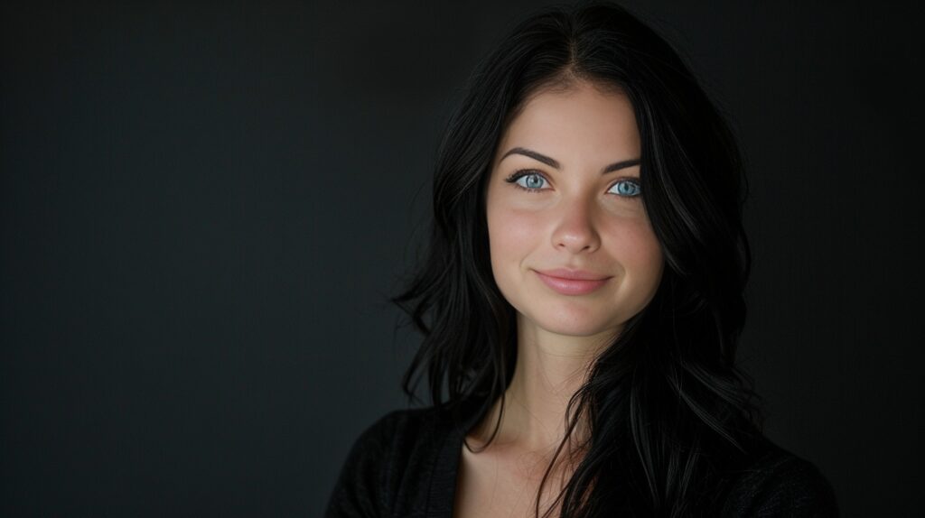 A woman with black hair and blue eyes is posing for a photo.